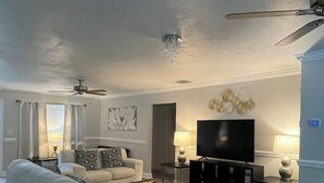 A living room with a sofa, coffee table, TV, and decorative items.