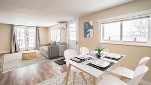 Una sala de estar moderna con comedor, ventanas grandes y vistas al exterior.