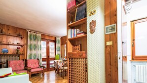 Un salón acogedor con muebles de madera, una estantería y vistas por una ventana.