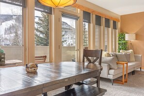 Un comedor con mesa de madera, sofá y lámpara.