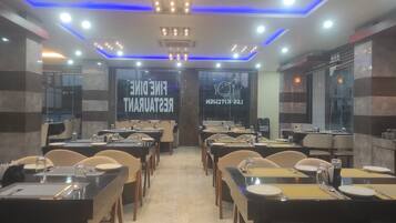 A restaurant interior with multiple dining tables and chairs, a modern ceiling design with blue lighting, and a sign reading "Fine Dining Restaurant".
