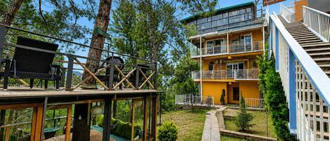 A multi-story building with balconies and a deck area with outdoor seating.
