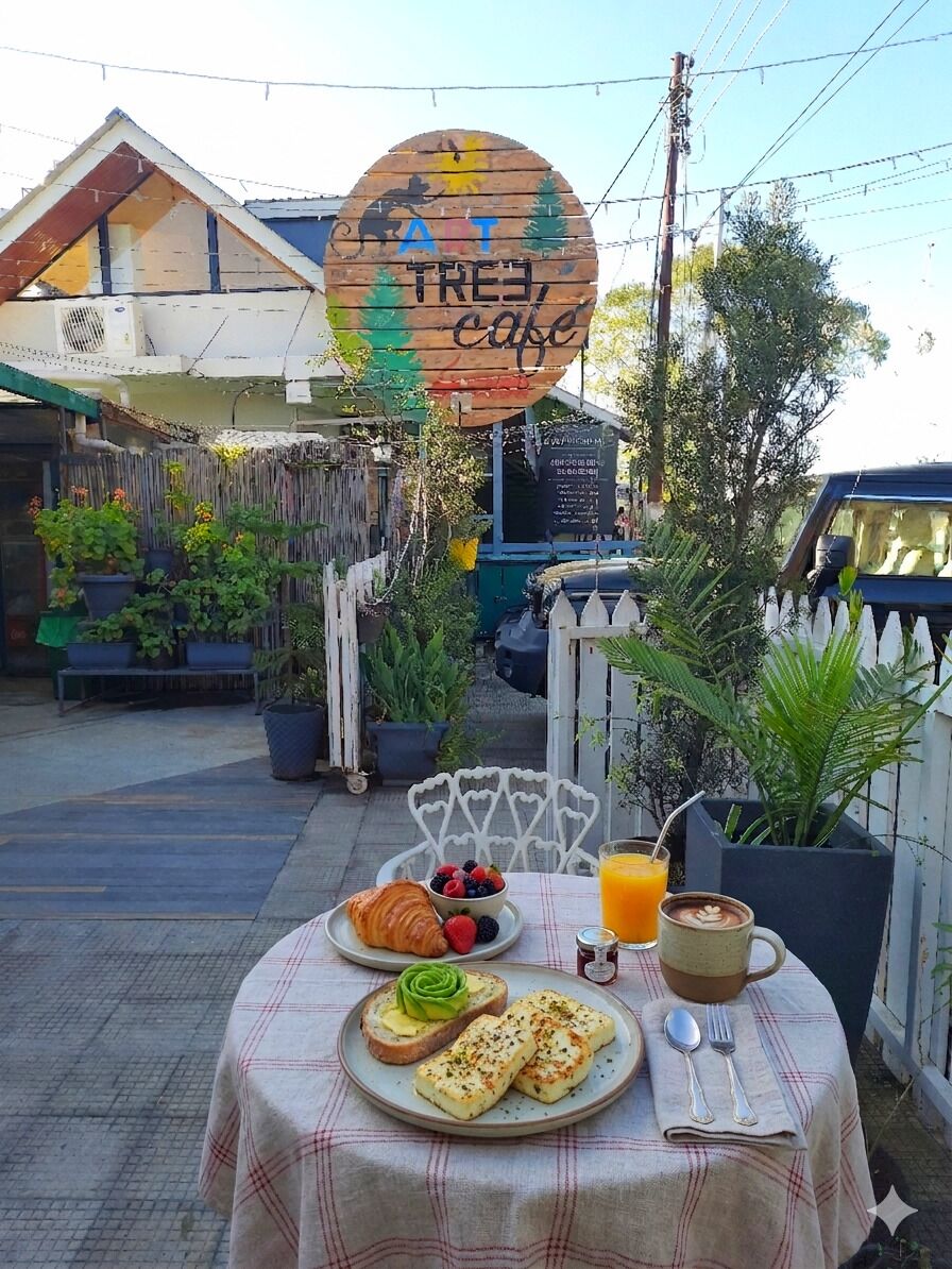 A table with breakfast items, a coffee cup, and a sign for a cafe.