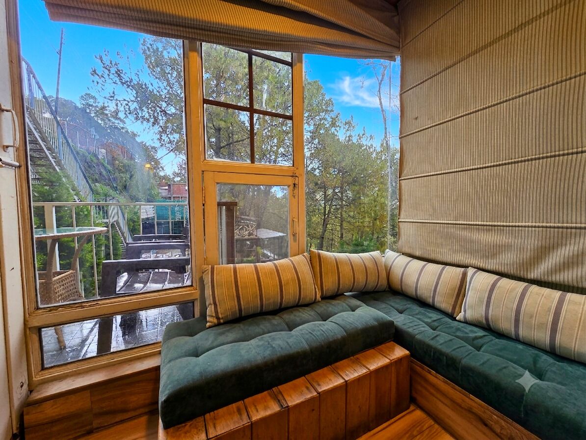 Un rincón acogedor con vistas a una terraza de madera y árboles.