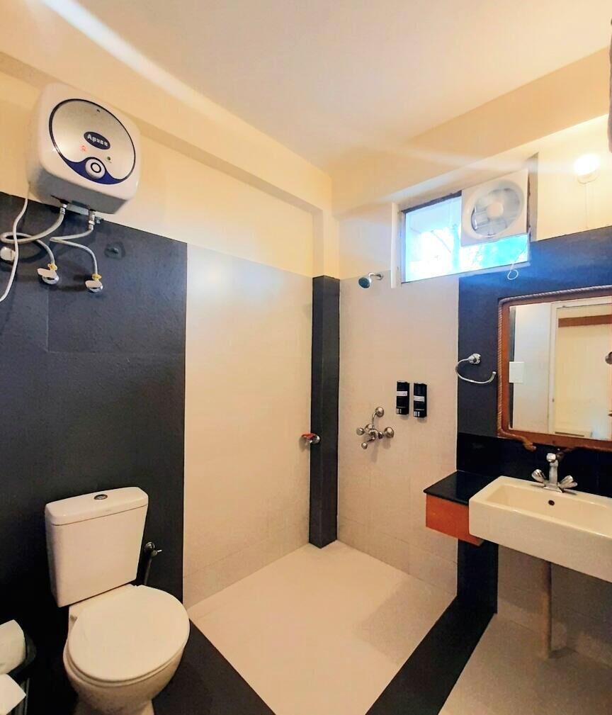 Une salle de bain moderne équipée d’un WC, d’une douche, d’un lavabo et d’un miroir.