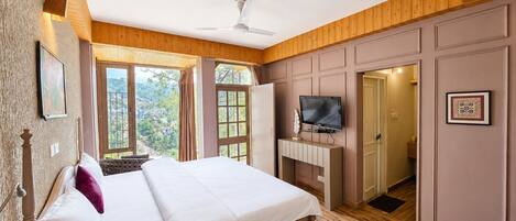 Un dormitorio con cama, televisión, ventilador de techo y vistas al exterior.