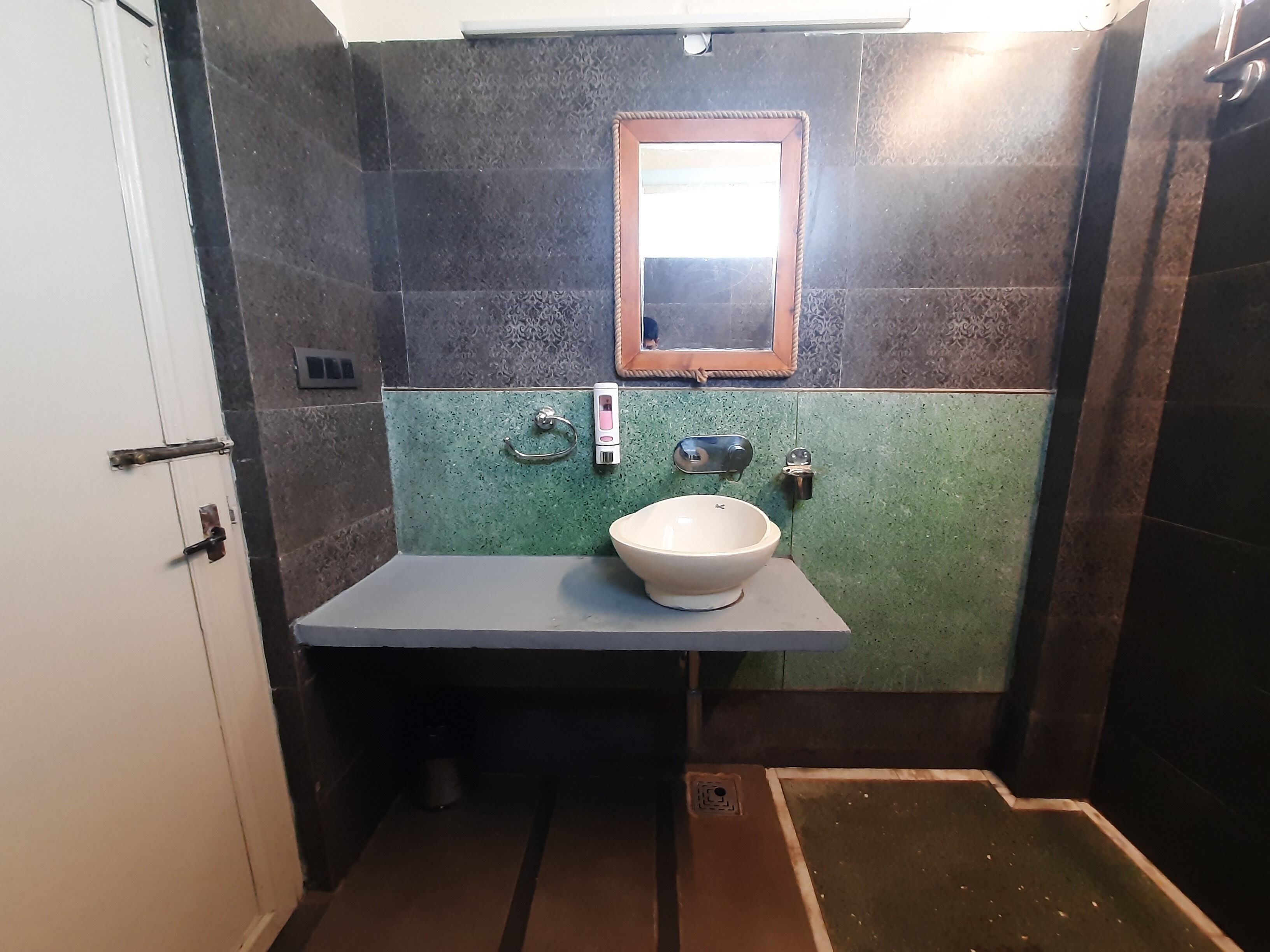 A bathroom with a white sink, a mirror, and a shower area.