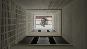 Espacio reducido y cerrado con ventanal y abanico decorativo.
