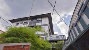 Un edificio de varios pisos con un balcón y un pequeño puente que une las diferentes plantas.