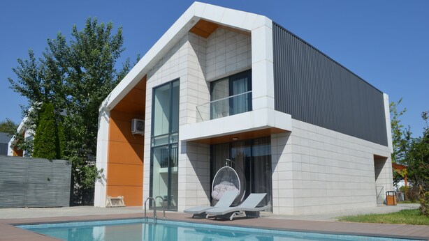 A modern building with a swimming pool, large windows, and a hanging chair by the pool. - Arena Villas Guba (Quba)