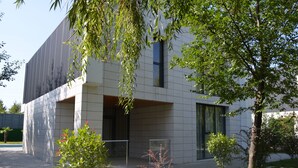 A modern building with a flat roof, large windows, and a paved entrance area. - Arena Villas Guba (Quba)