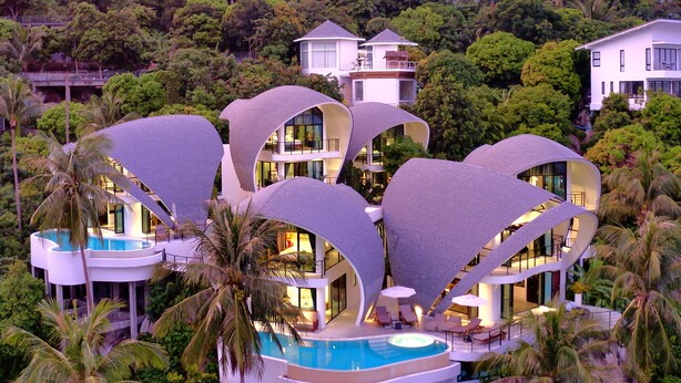 A modern resort with unique curved architecture, a central pool, and lush tropical surroundings. - Room B8 - PANORAMIC SEA VIEW (Koh Samui)