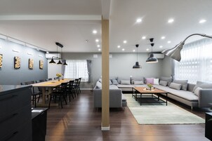 Un salon moderne avec un canapé, une table basse et un coin repas avec des chaises.