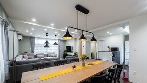 A modern kitchen with a wooden table, black chairs, and pendant lights. - FC Farnest Niseko (Kutchan)