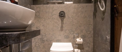 A modern bathroom with a large sink, toilet, and shower.
