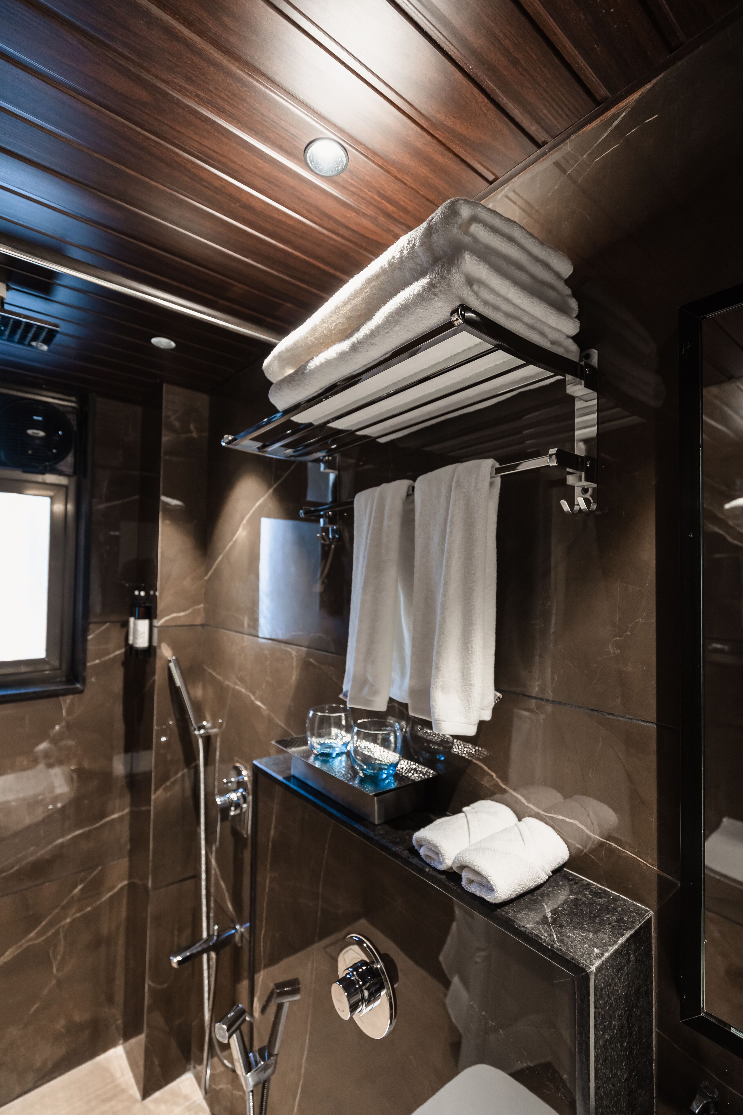 Une salle de bain moderne avec une douche à parois de verre, un meuble-lavabo avec un miroir et un porte-serviettes avec des serviettes pliées.