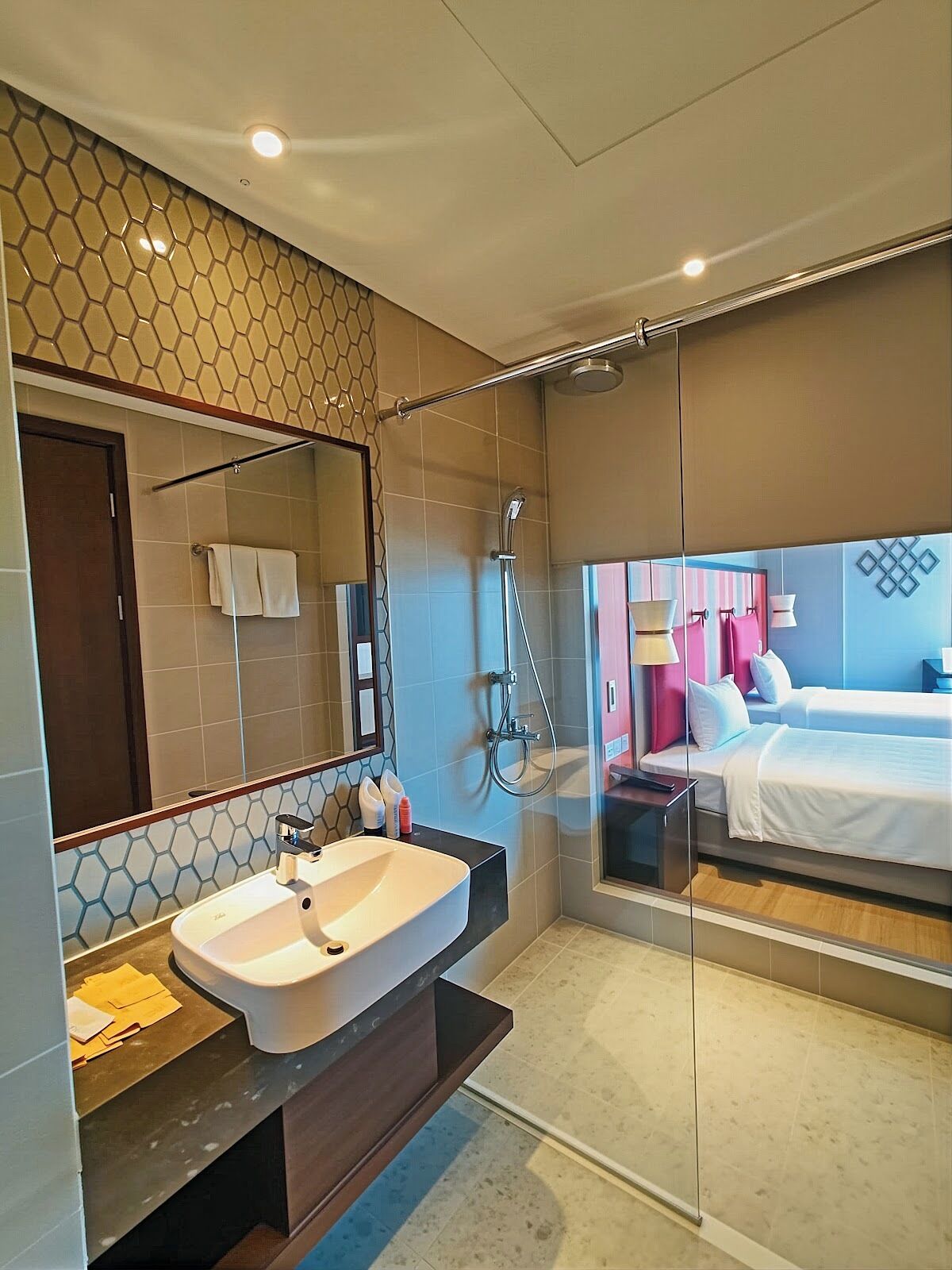 A modern bathroom with a large mirror, a sink, and a shower.
