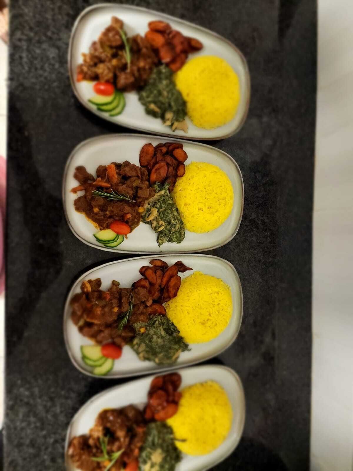 Three plates of food with yellow rice, meat, and vegetables.