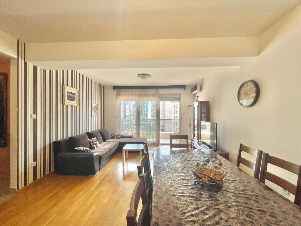 Amplia sala de estar con una mesa de comedor, un sofá y un televisor.