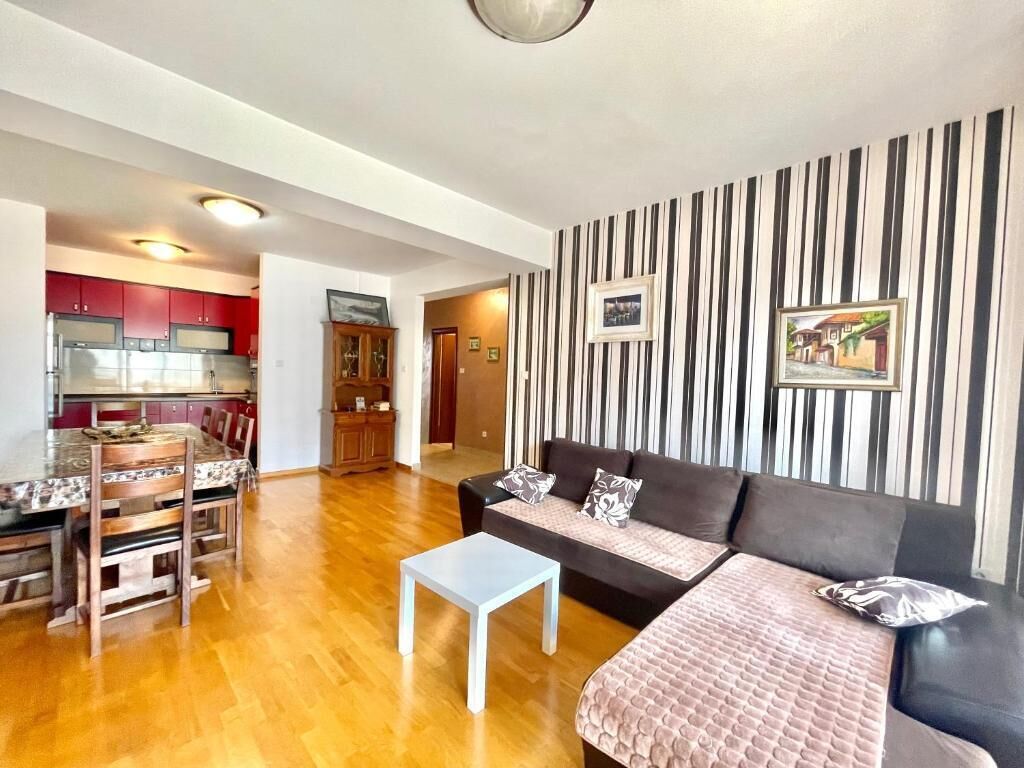 Una sala de estar moderna con sofá, una mesa de centro y un comedor con mesa y sillas.
