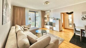 Una sala de estar moderna con un sofá, una mesa de centro y un comedor con sillas.