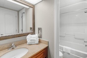 Ein Badezimmer mit Waschbecken, Spiegel und Dusche.