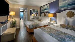 A hotel room with two beds, a desk, a chair, a TV, and artwork on the walls. - Magnificent Oceanfront Suite: 11th Flr (Myrtle Beach)