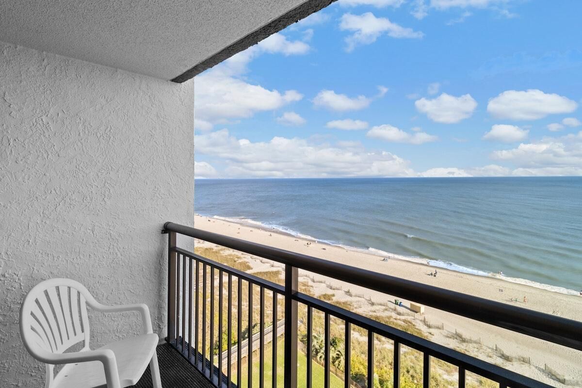 Een balkon met uitzicht op een strand en de oceaan.