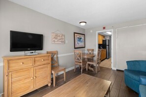 A living room with a TV, wooden furniture, and a dining area. - Astonishing Oceanfront Ste 12th Flr with Breakfast (Myrtle Beach)