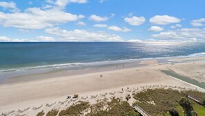 A beach with a sandy shore, a wooden walkway, and a clear sky. - Spacious Oceanfront Suite with Breakfast 14th Flr (Myrtle Beach)