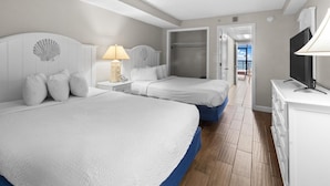 A hotel room with two beds, a TV, a lamp, and a view of the sea. - Spacious Oceanfront Suite with Breakfast 14th Flr (Myrtle Beach)