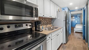 A modern kitchen with stainless steel appliances, white cabinets, and a tiled backsplash. - Oceanfront King Suite: Free Breakfast 15th Floor (Myrtle Beach)