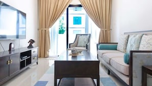 A modern living room with a sofa, coffee table, TV, and curtains. - A Comfy & Cozy Suasana Suites in Johor Bahru (Johor Bahru)
