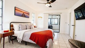Een moderne slaapkamer met een bed, nachtkastje en een plafondventilator.
