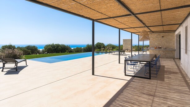 A covered outdoor area with a pool, seating, and a view of the sea. - Panoramic luxury villa with private pool in Sampieri - Di Casa In Sicilia (Sampieri)