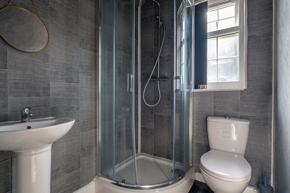A bathroom with a glass-enclosed shower, a white sink, and a toilet. - Inviting 1-bed Studio2 in Coventry (Coventry)