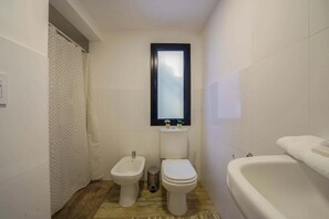 Ein Badezimmer mit Bidet, Toilette und Badewanne.