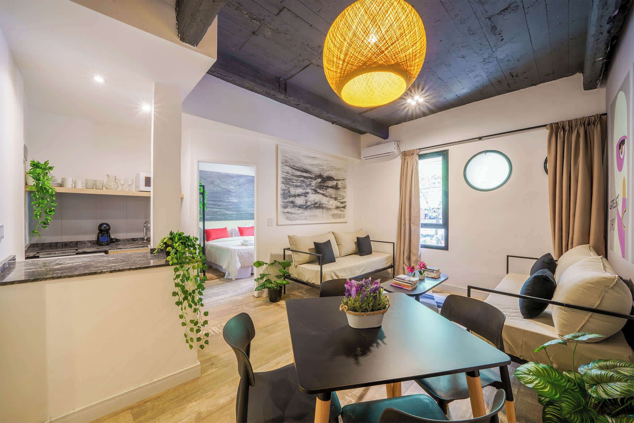 A modern living space with a kitchen, dining area, and seating area.
