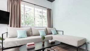 Un salon moderne avec un canapé, une table basse et un téléviseur.