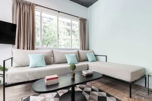 Una sala de estar moderna con un sofá, una mesa de centro y un televisor.
