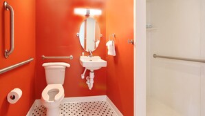 Un baño con inodoro blanco, lavamanos y espejo.