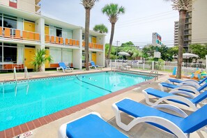 A hotel pool area with lounge chairs and a swimming pool. - Holiday Shores - ADA Standard King Room (Myrtle Beach)