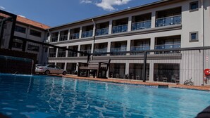 A hotel with a swimming pool, a covered area, and a multi-story building with balconies. - Acres Inn Klerksdorp (Klerksdorp)