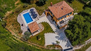 An aerial view of a property with a swimming pool, outdoor seating area, and a building with a tiled roof. - Amazing home in Labin - Rabac (Labin - Rabac)