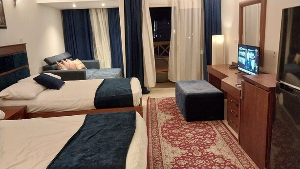 Ett hotellrum med två sängar, en TV, ett skrivbord och utsikt över omgivningarna.