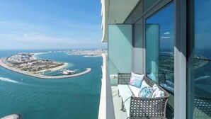 A balcony with a view of a coastal area, including a marina and a small island. - Vogue | Beach Vista near Palm Jumeirah | JBR (Dubai)