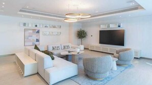 A modern living room with a sectional sofa, a flat-screen TV, and a coffee table. - Vogue | Beach Vista near Palm Jumeirah | JBR (Dubai)