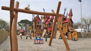 A playground with wooden climbing structures and slides. - Bungalow with air conditioning, terrace and pool (Fossalta)