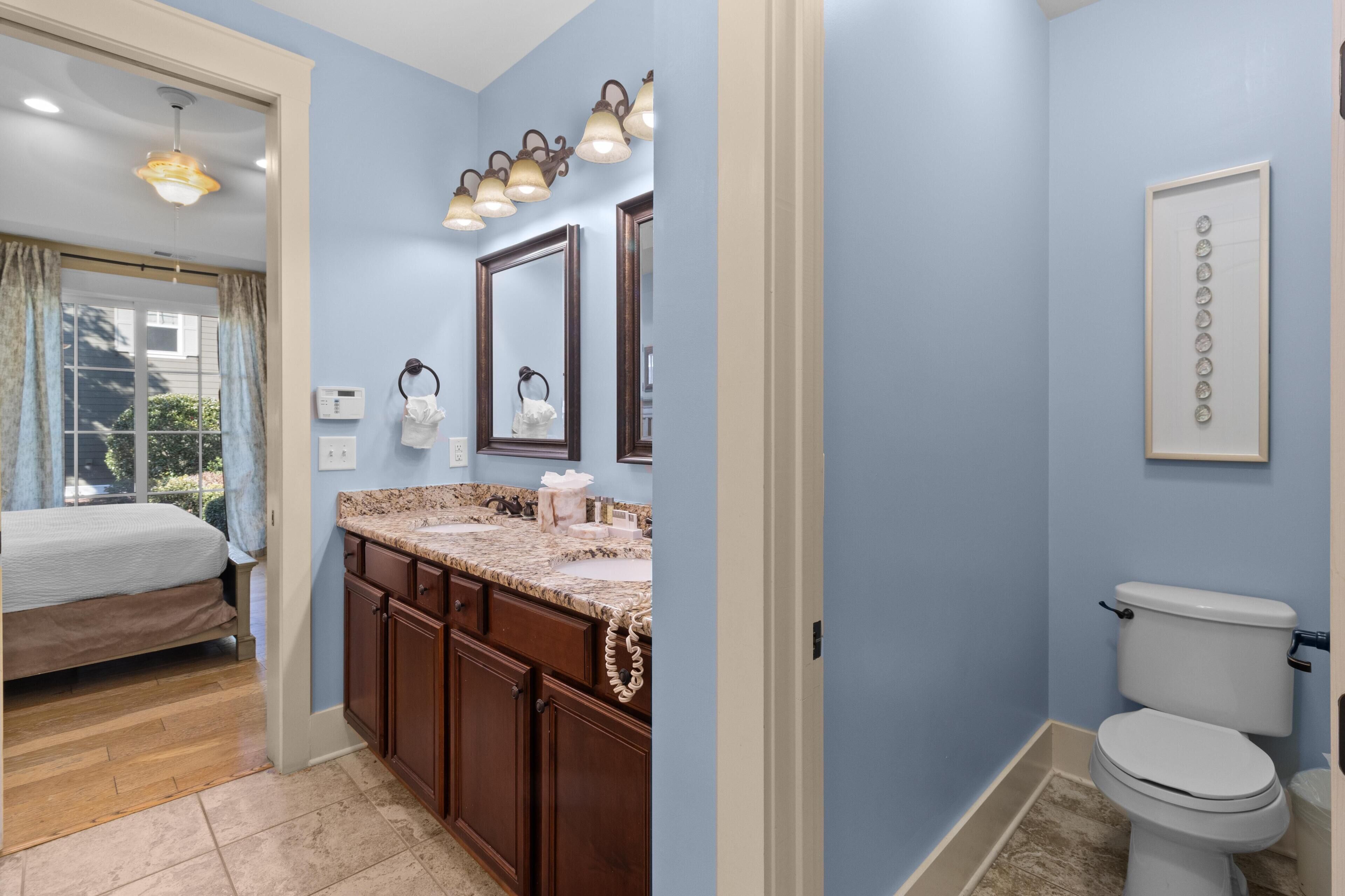 Une salle de bain avec un lavabo, un miroir et des toilettes.