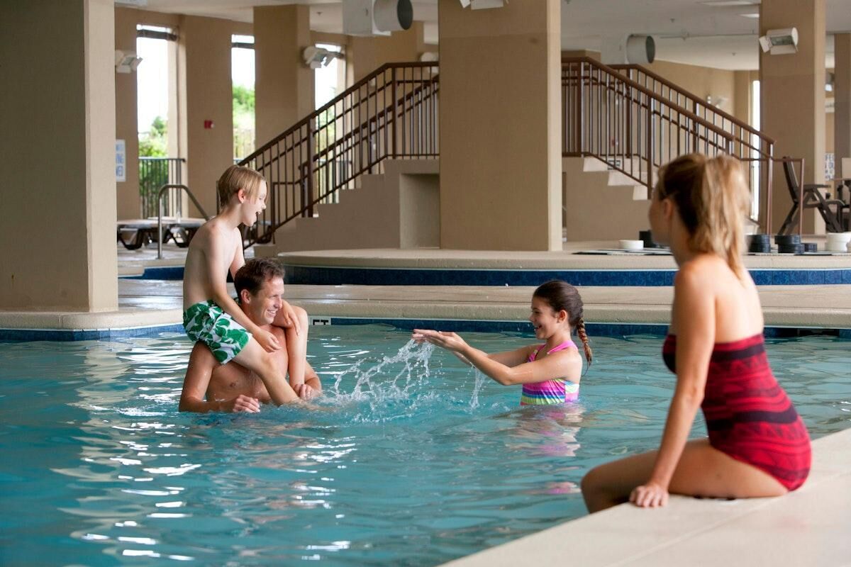 An indoor swimming pool with a staircase in the background.